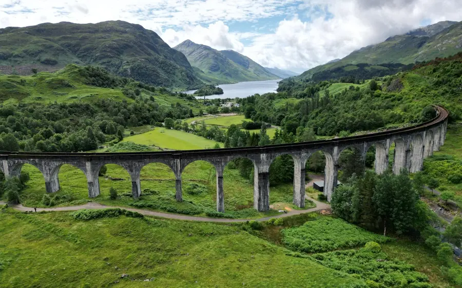 A steam train crossing the Glenfinnan viaduct in summer